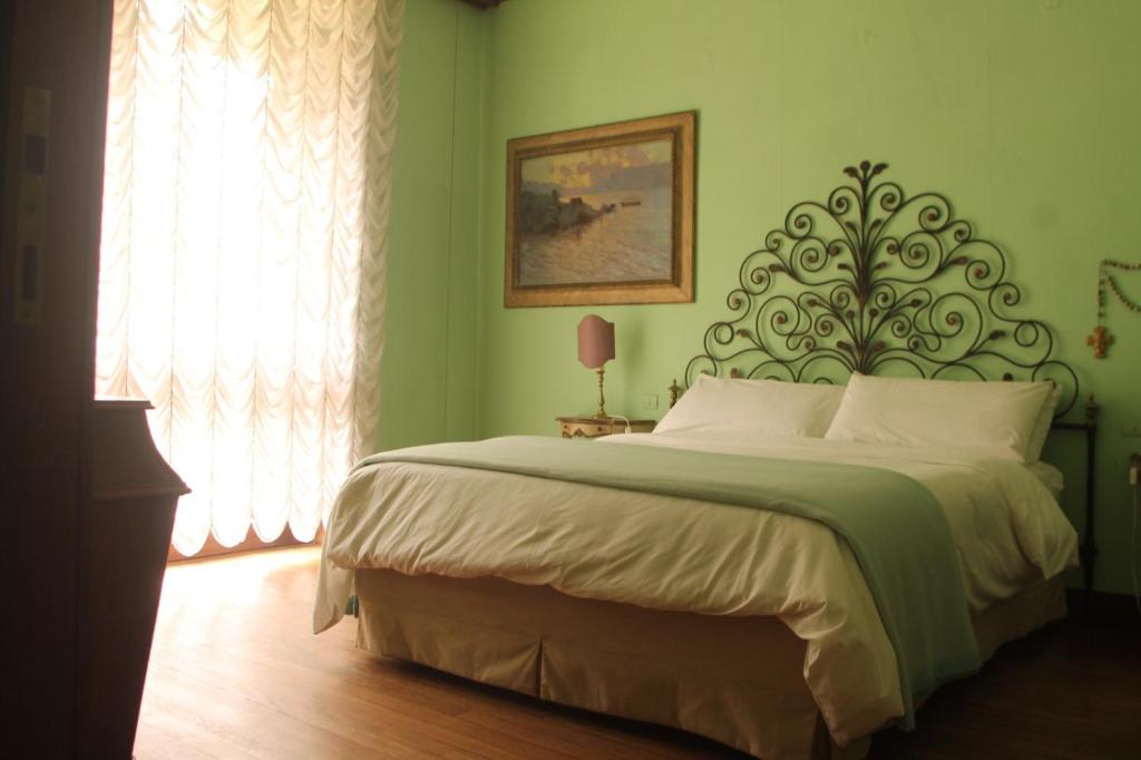 OggionoVilla Inella的一间位于绿色客房内的卧室,配有一张大床