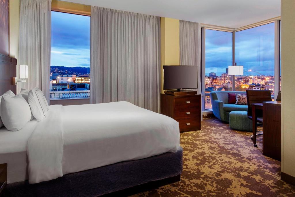 波特兰Courtyard by Marriott Portland City Center的酒店客房享有城市美景,配有一张床。
