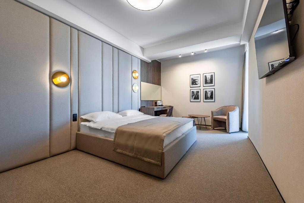 基希讷乌摄政酒店的一间卧室配有一张床、一张桌子和一把椅子