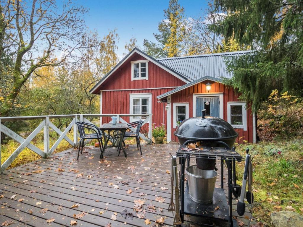 TallnäsHoliday Home Puutarhurin mökki by Interhome的红房子前面甲板上的烤架