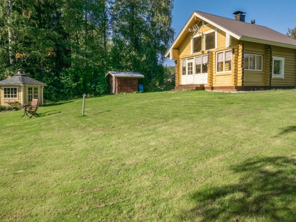 KosulaHoliday Home Ahvenranta by Interhome的一座黄色的房子,位于一个草场上,有一座建筑