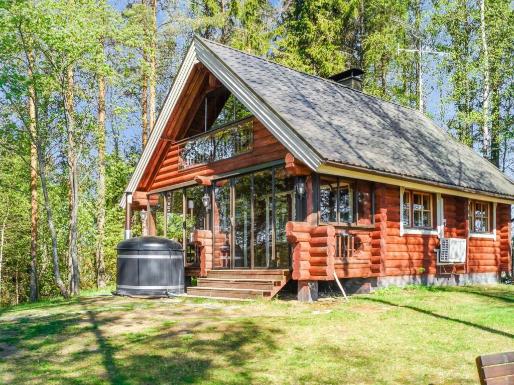 PuromäkiHoliday Home Huvilakoti 1 by Interhome的树林中的小木屋,设有大窗户