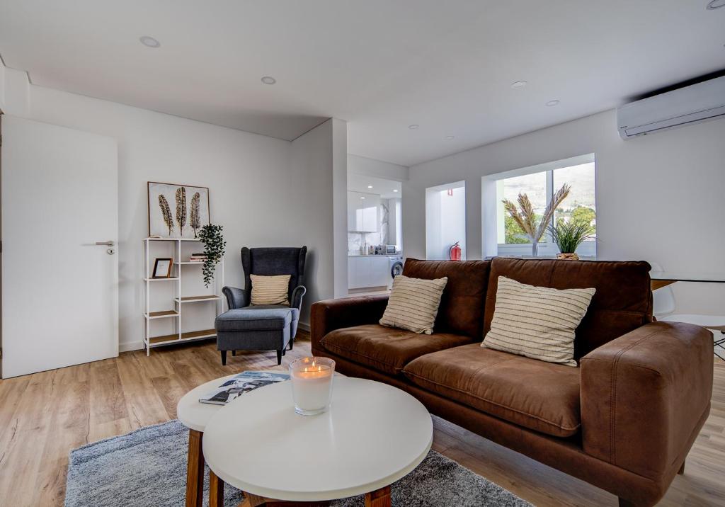科维良Apartamento Rodrigo的客厅配有棕色沙发和白色桌子