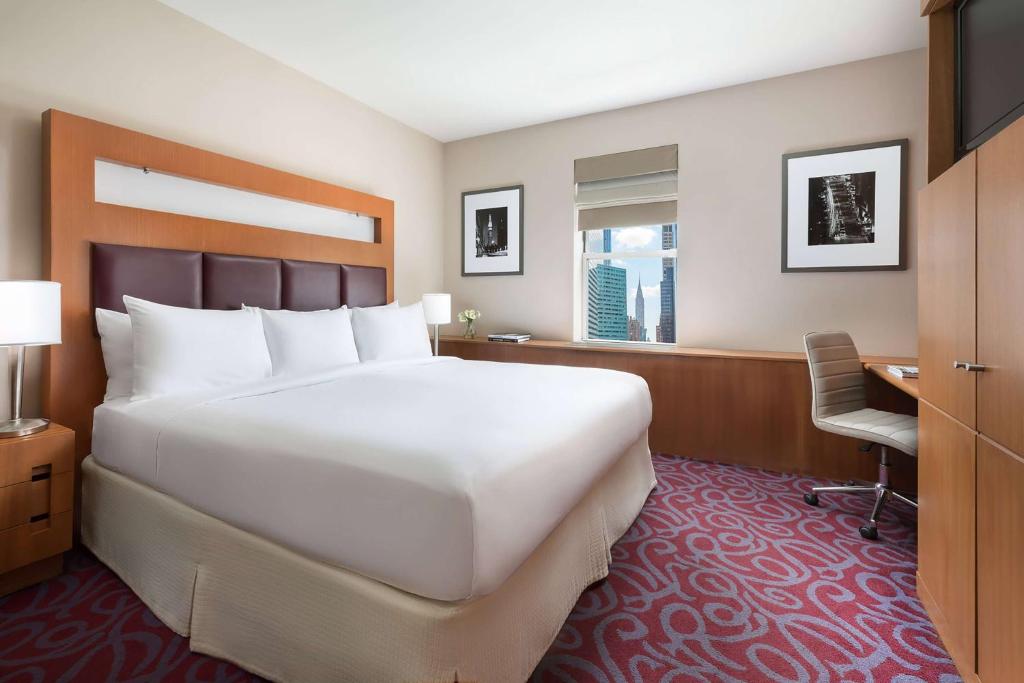 纽约Hotel 57 by LuxUrban的卧室配有一张白色大床和一张书桌