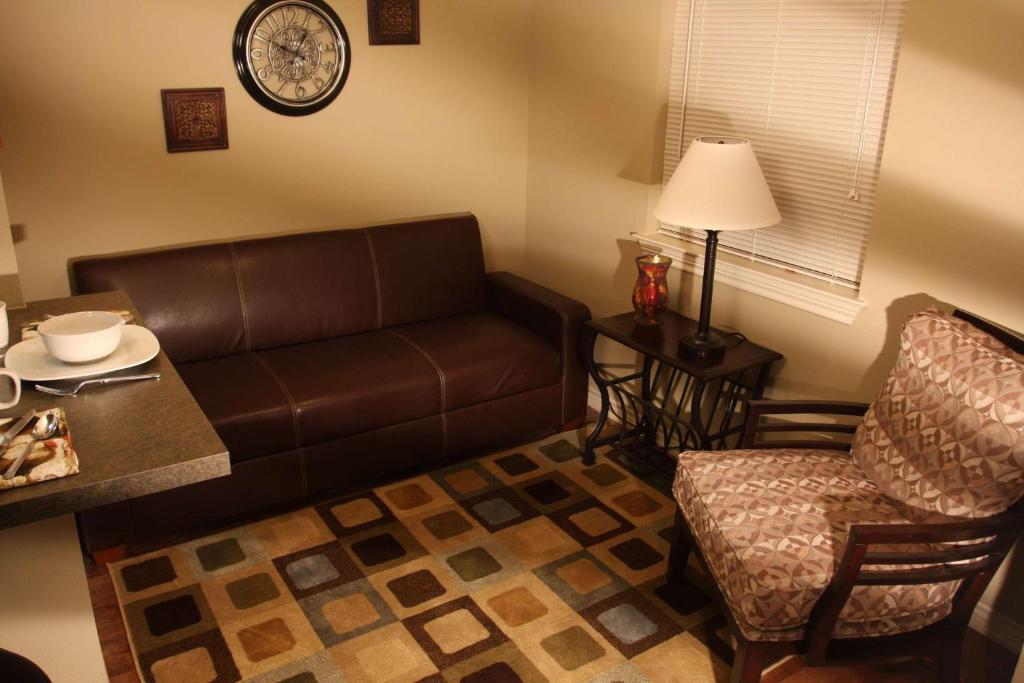 安德鲁斯Eagle's Den Suites Andrews a Travelodge by Wyndham的客厅配有沙发和椅子