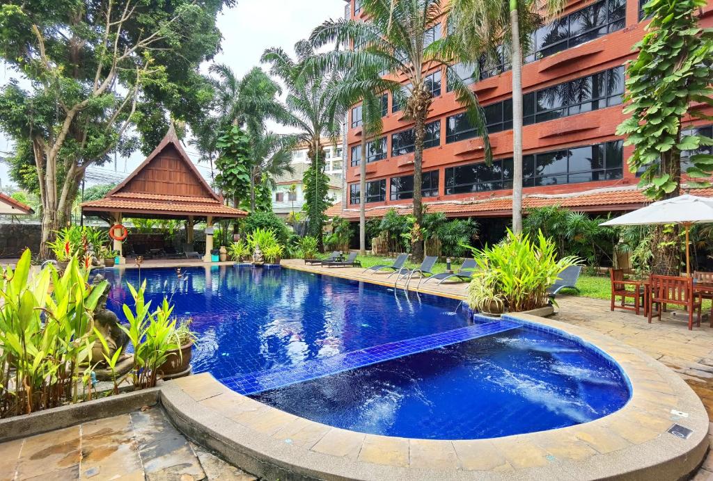 芭堤雅市中心Nova Park Hotel Pattaya的大楼前的游泳池