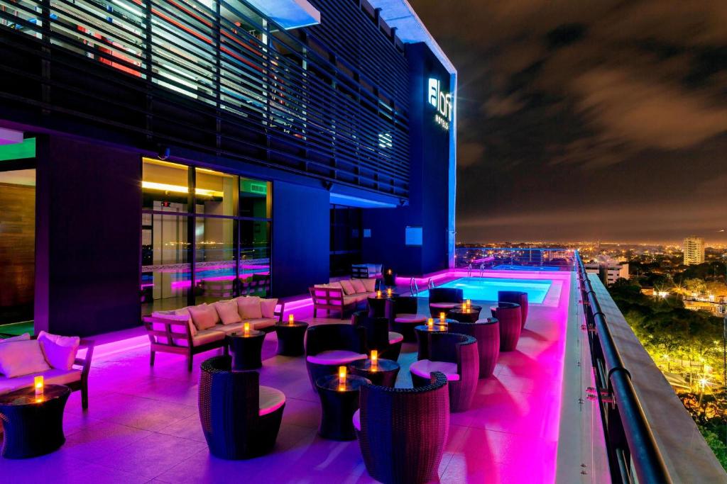 亚松森亚松森雅乐轩酒店的建筑中屋顶酒吧,拥有紫色灯光