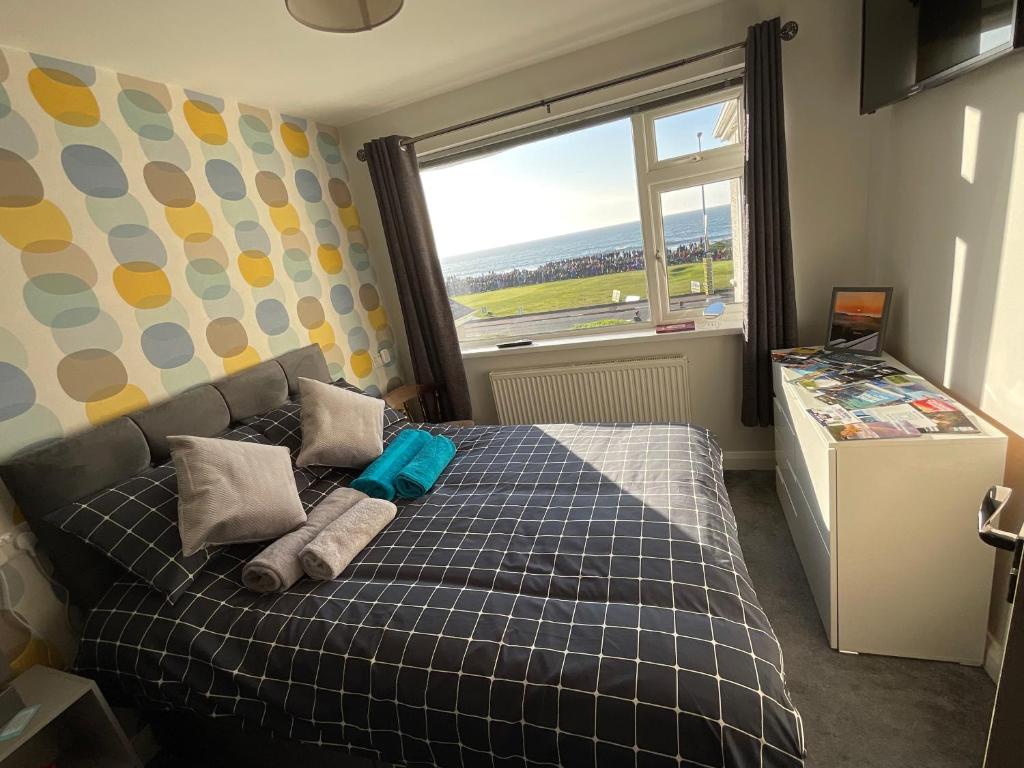 斯图尔特港NUMBER 5 Portrush Road, Portstewart的一间卧室配有一张带铺着地毯的床和窗户。