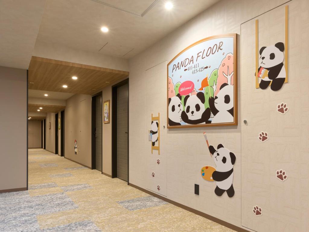 东京Mitsui Garden Hotel Ueno - Tokyo Reopened in July 2023的墙上挂着熊猫的走廊
