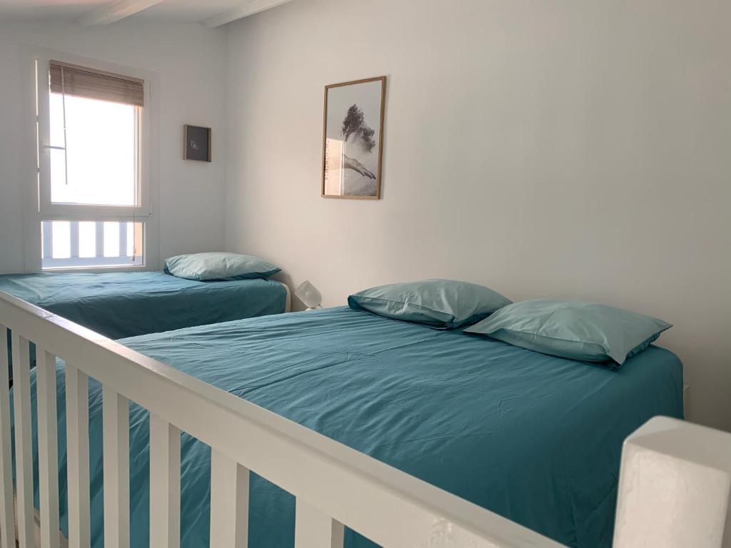 圣马迪拉莫Appartement de standing avec terrasse的一间卧室配有两张床和一张婴儿床。
