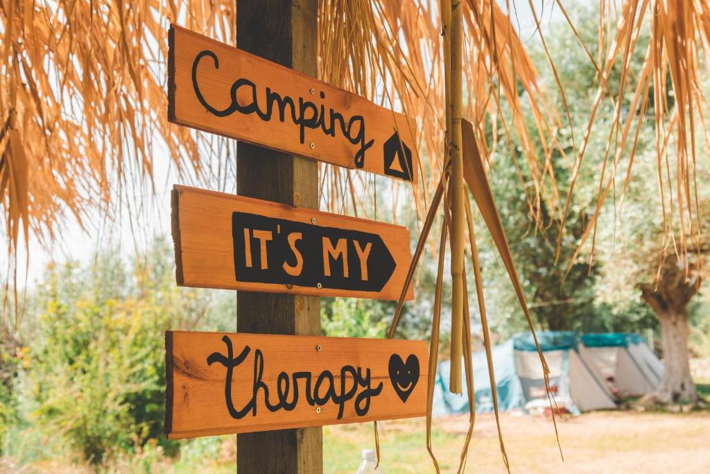 希马拉Olive Camping的有一根标有指示牌的杆子,表示要把我的治疗挂在里面
