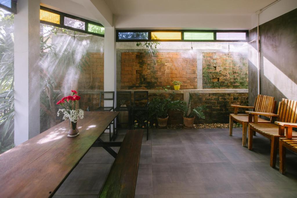 清迈LD8 House Private Pool Perfect Groups -Families ChiangMai的餐厅设有木桌和椅子,拥有砖墙