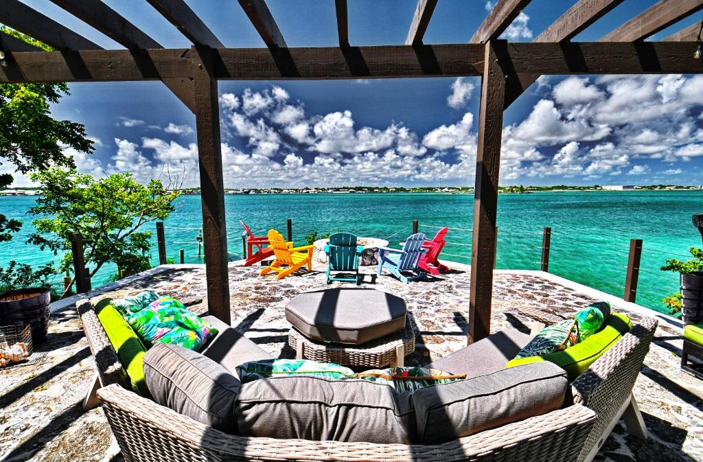 马尔斯港Harbour Beach Villa - large dock & great views!的一个带沙发和椅子的庭院和水