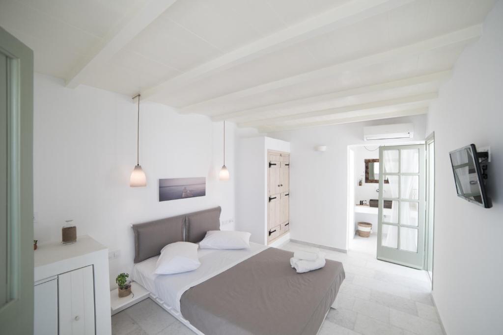 纳克索乔拉纳斯塔西娅公寓式酒店的一间白色卧室,配有床和电视
