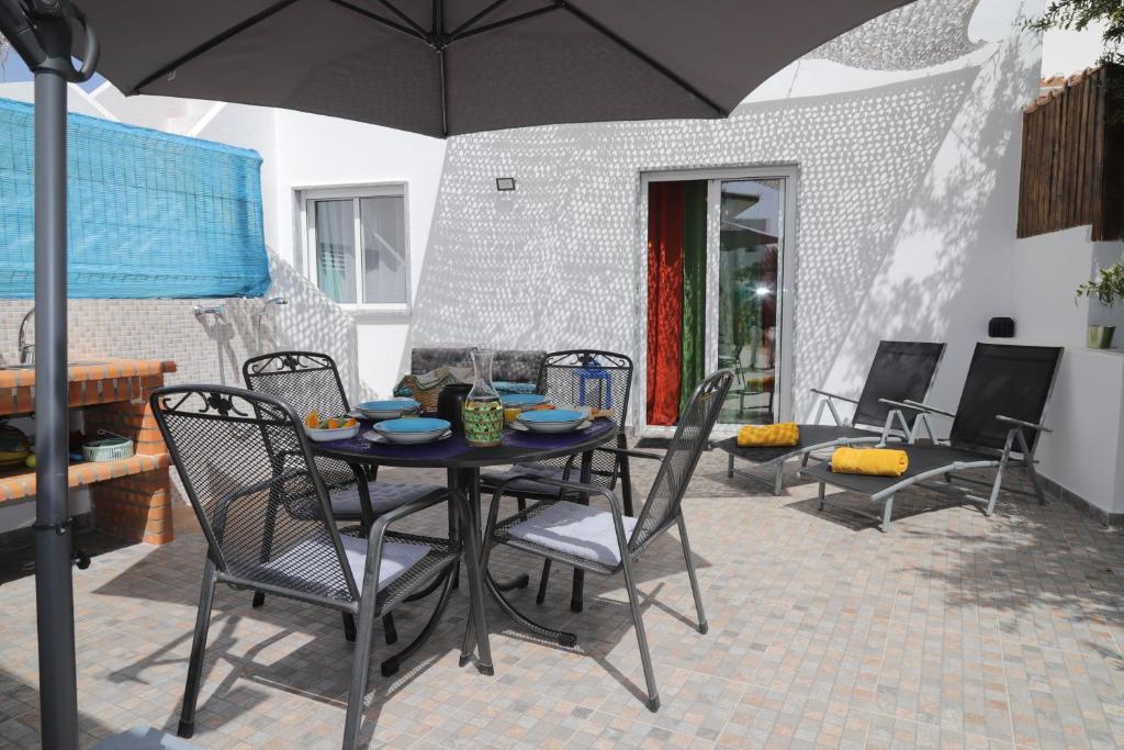 维拉诺瓦德卡塞拉Catita Home的庭院内桌椅和遮阳伞