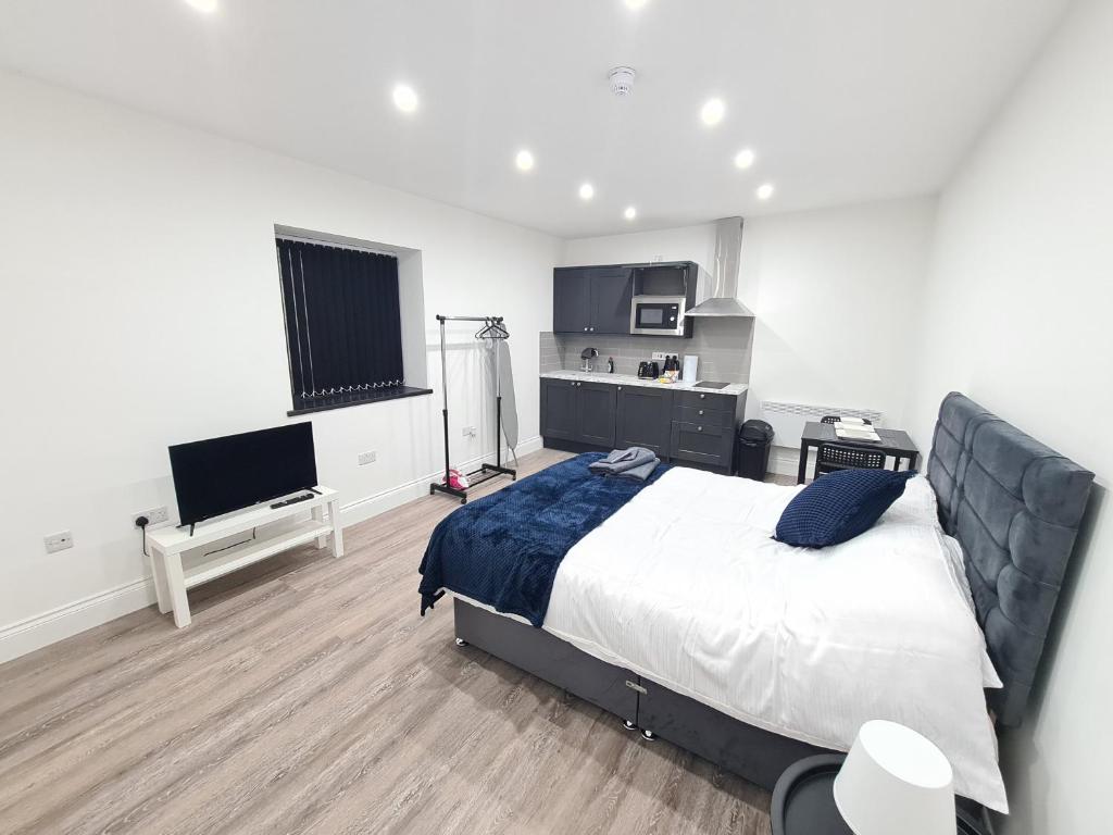 Batley CarrHomestay by BIC Legends 5的一间卧室配有一张大床和电视