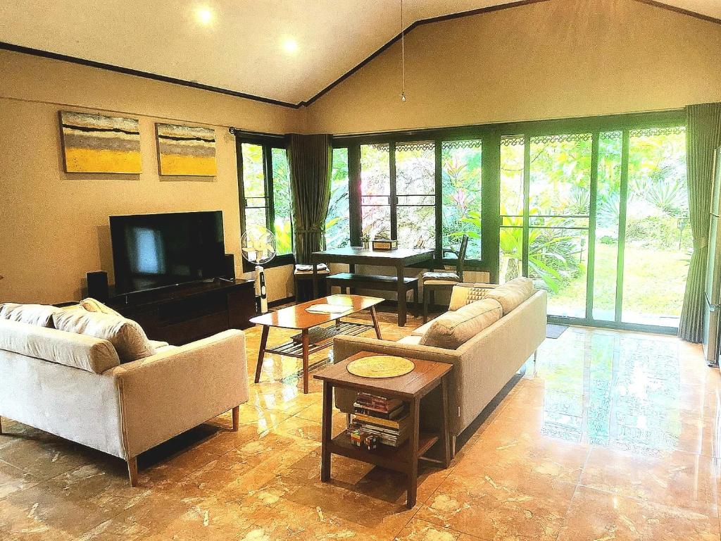Ban Muang SoiUTOPAI Stone Garden Vacation Home, Pai!的客厅配有两张沙发和一台电视