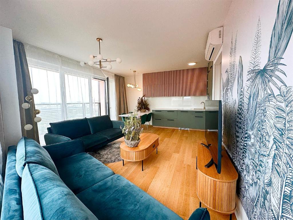 布拉迪斯拉发Luxurious brand new FREE parking apartment的一间带蓝色沙发的客厅和一间厨房