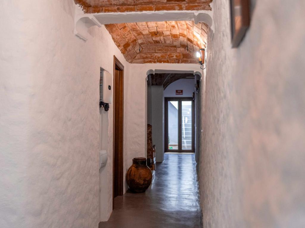 Casa Rural El Palomeque的拥有白色墙壁和木制天花板的走廊