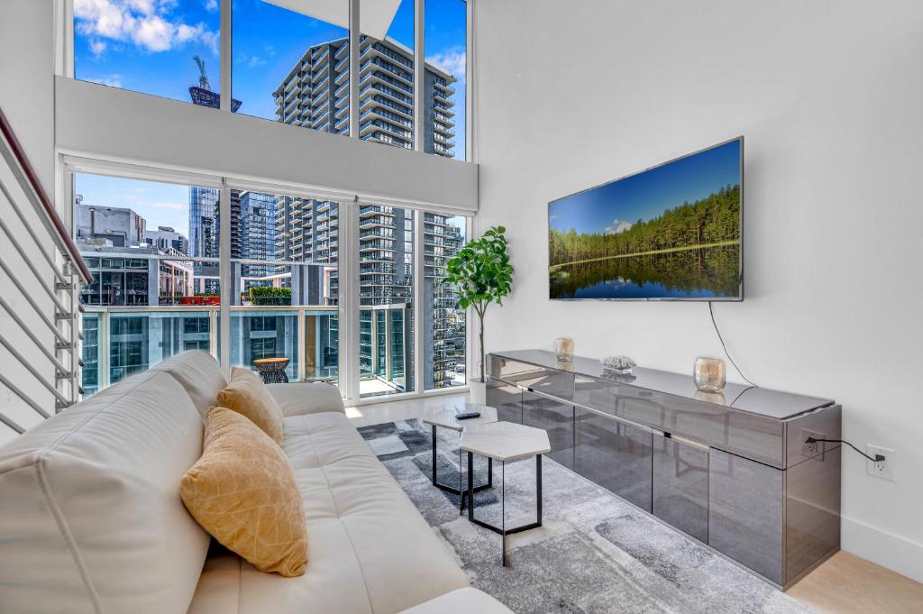 迈阿密Stunning 1 Bedroom Loft in The Heart of Brickell的客厅配有白色沙发和大窗户