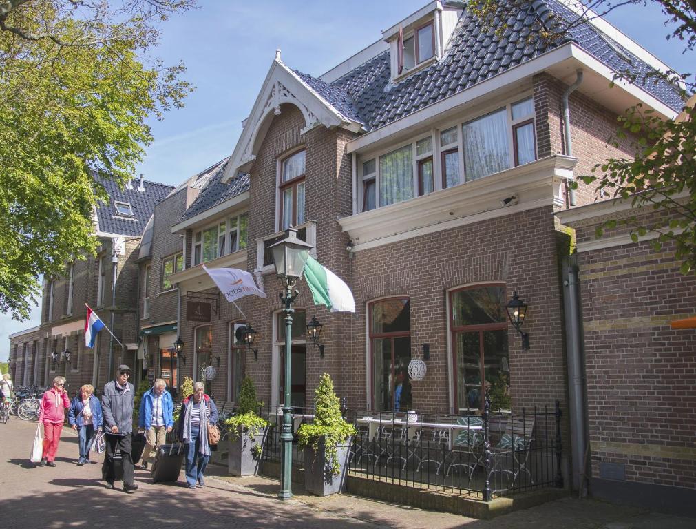 东弗利兰Loods Hotel Vlieland的一群人走在房子前面