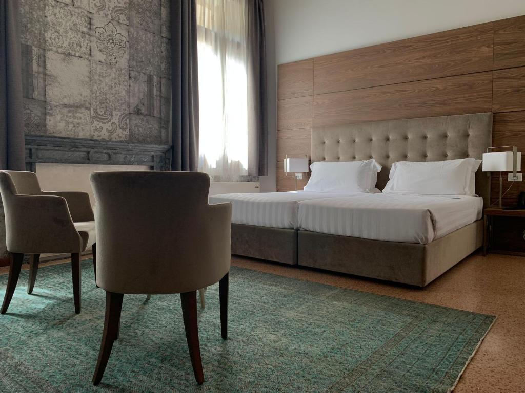维琴察Palazzo Scamozzi的一间卧室配有一张大床和两把椅子