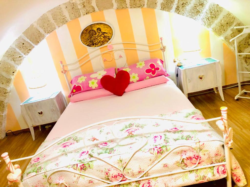 莫尔费塔SOTTO L’ARCO DI NUNZIELLA的一间卧室配有一张带心枕的床
