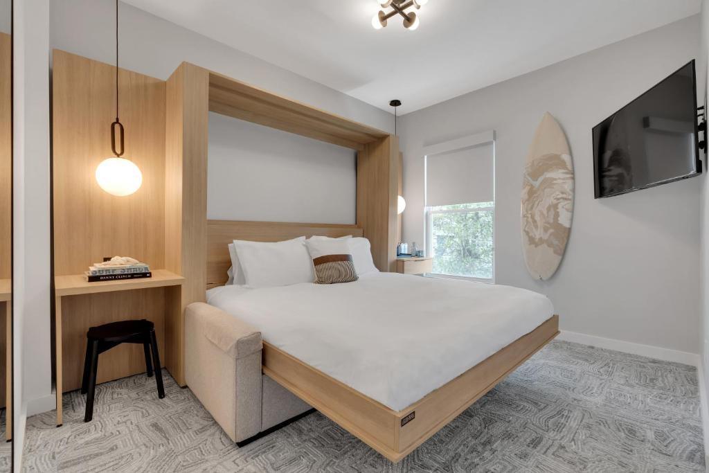 艾斯拜瑞The St Laurent Guest Rooms的一间卧室配有一张床、一张书桌和一台电视