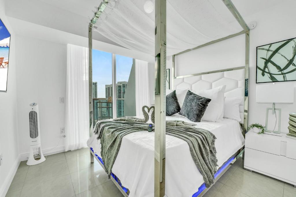 迈阿密Modern 2 Story Loft 2BR with Breathtaking Views的白色卧室设有天蓬床和窗户