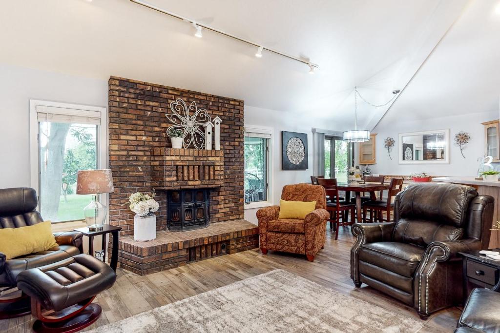 Apple Cottage的客厅设有砖砌壁炉和椅子