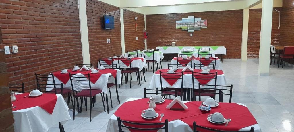 特尔马斯德里奥翁多Hotel Sol的一间设有红色和白色桌椅的用餐室