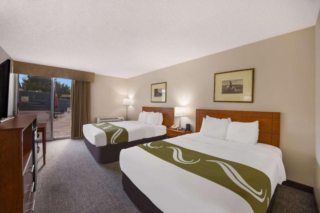 卡农城Quality Inn & Suites Canon City的酒店客房设有两张床和一个阳台。