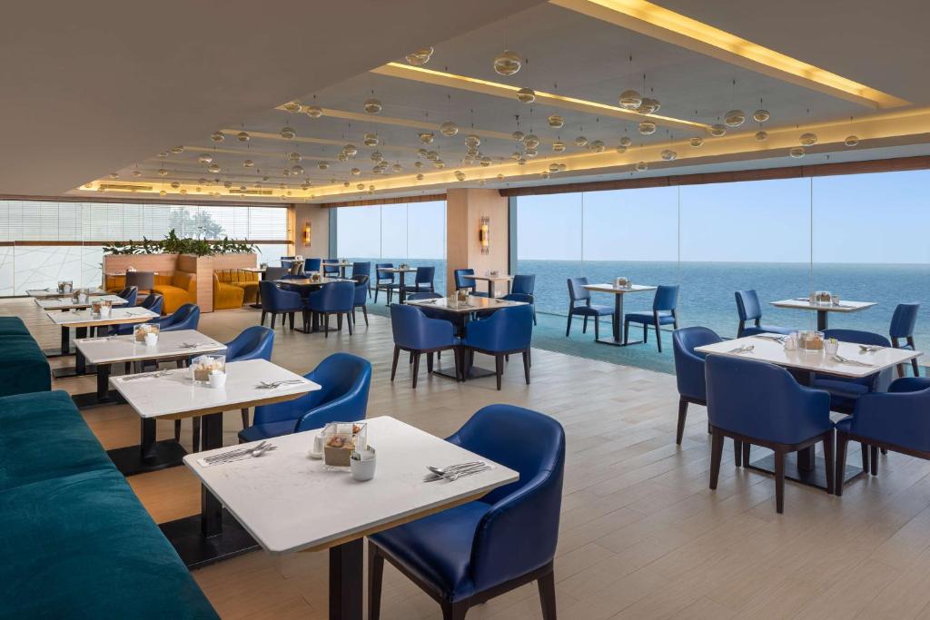 科伦坡Radisson Hotel Colombo的一间设有桌椅的海洋餐厅