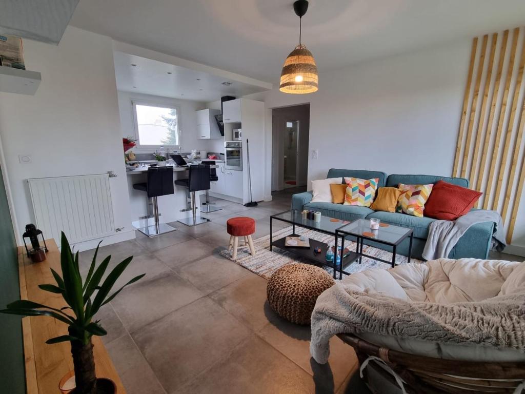 马恩河畔维列Cosy Colour Place的一间带蓝色沙发的客厅和一间厨房