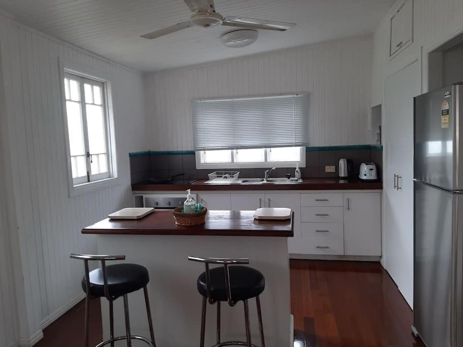 Wangan Tropical Getaway的厨房配有冰箱和2个吧台凳