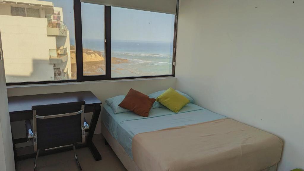 曼塔Departamento vista al mar en Manta Poseidon的窗户客房内的床和书桌