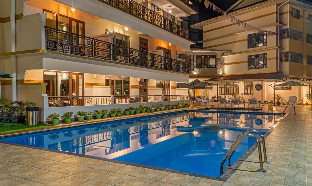 甘托克Treebo Tryst Tempo Heritage Spa & Resort的酒店游泳池的背景是酒店
