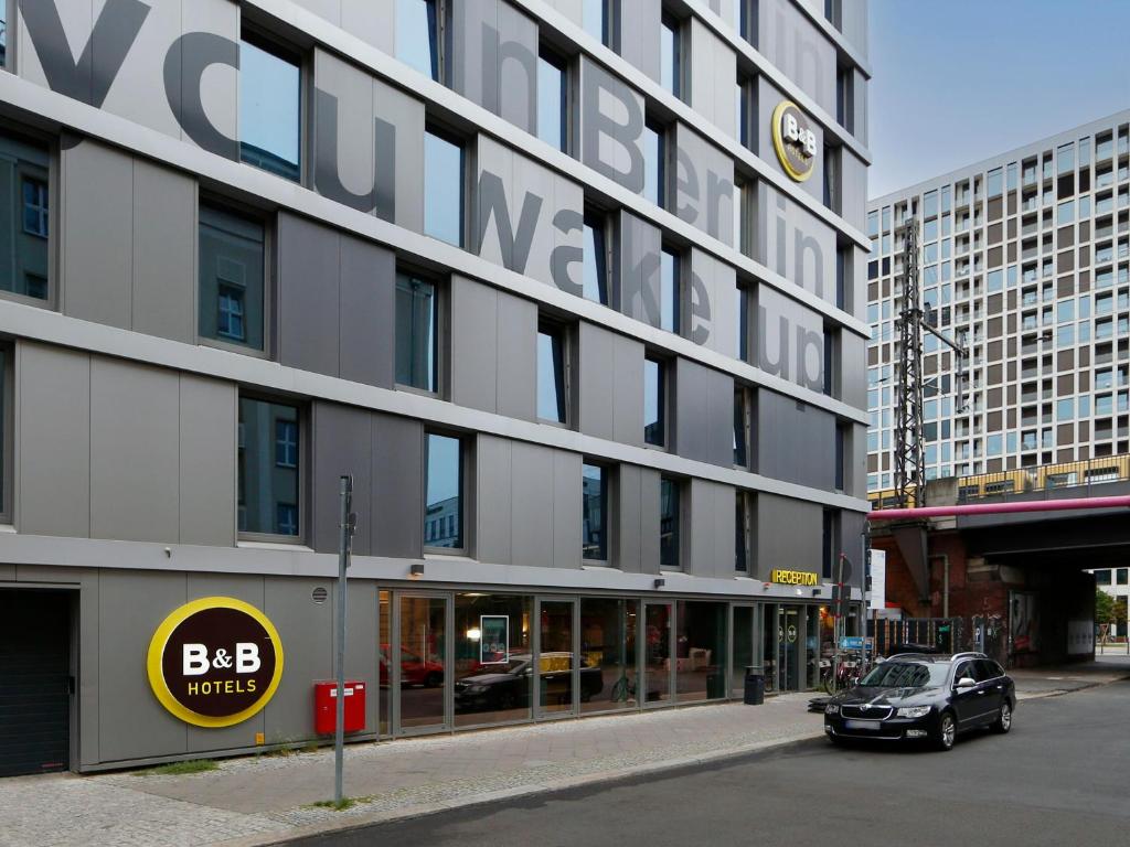 柏林B&B HOTEL Berlin-Alexanderplatz的停车场停在大楼前