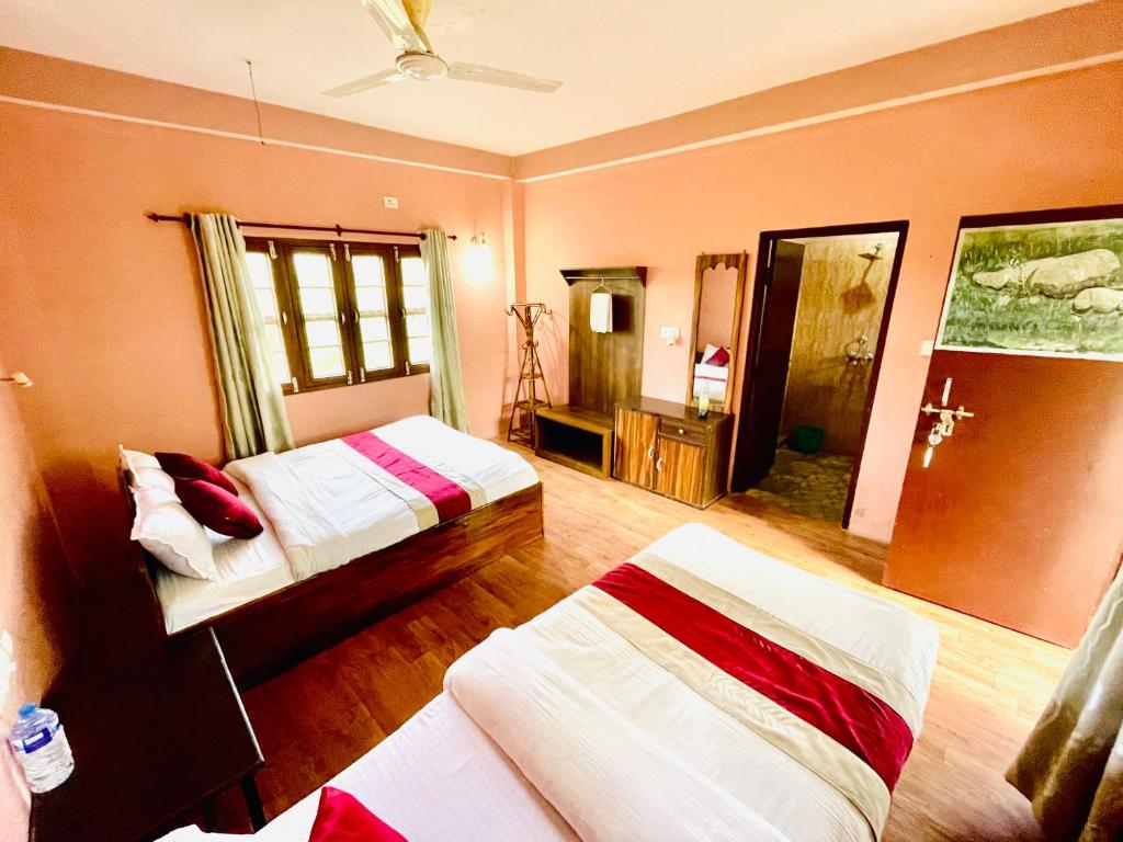 奇旺Hotel Tree Tops- A Serene Friendly Hotel in Sauraha的一间卧室,配有两张床