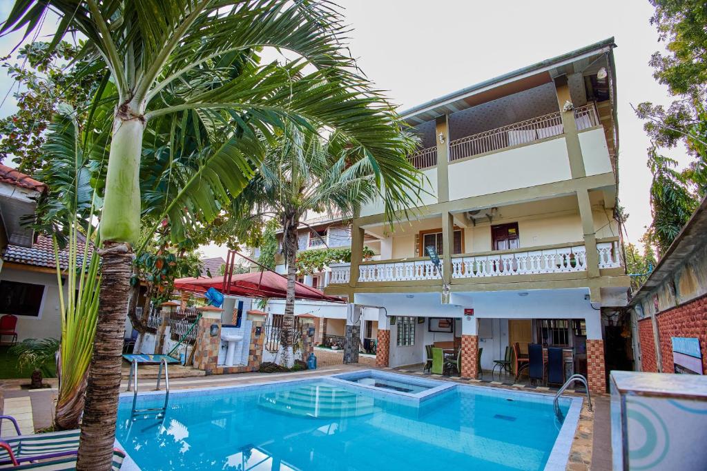迪亚尼海滩Diani Home Stays的棕榈树酒店前的游泳池