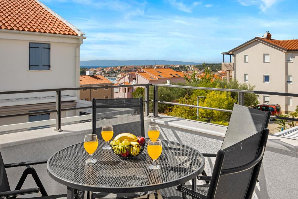 茨雷斯Apartments Tim & Klara - Sunny Cres Island的阳台上的桌子上摆放着酒杯和一碗水果