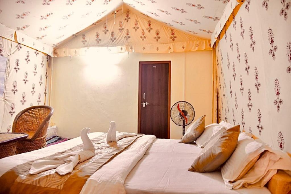 斋沙默尔Mathar Ki dhani的帐篷内一间卧室,配有一张大床