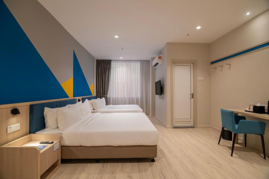 新山Fives Hotel Meldrum的配有一张床和一张书桌的酒店客房