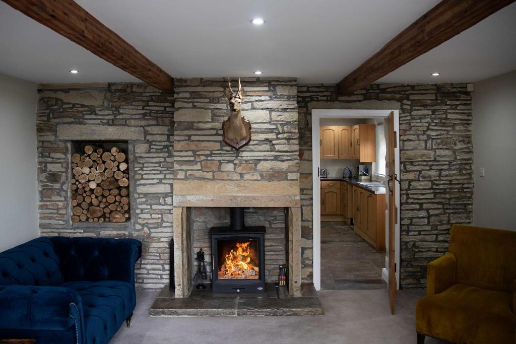 哈利法克斯Croft House Cottage的客厅设有带壁炉的石墙