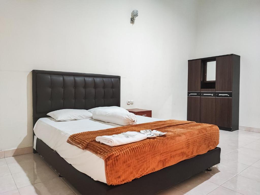 KinatiRedDoorz Plus Syariah near Simpang Rimbo Jambi的一间卧室配有一张大床和两条毛巾