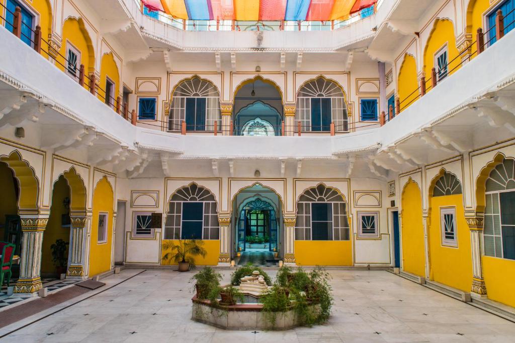 斋浦尔Diggi Palace A Luxury Heritage Hotel的一间设有黄色墙壁和天花板及喷泉的房间