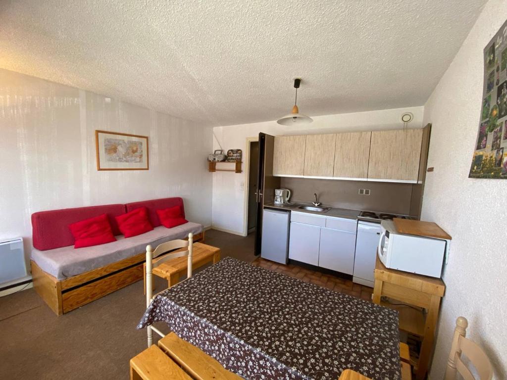 拉普德兹Appartement Huez, 1 pièce, 4 personnes - FR-1-405-48的一间带红色沙发的客厅和一间厨房