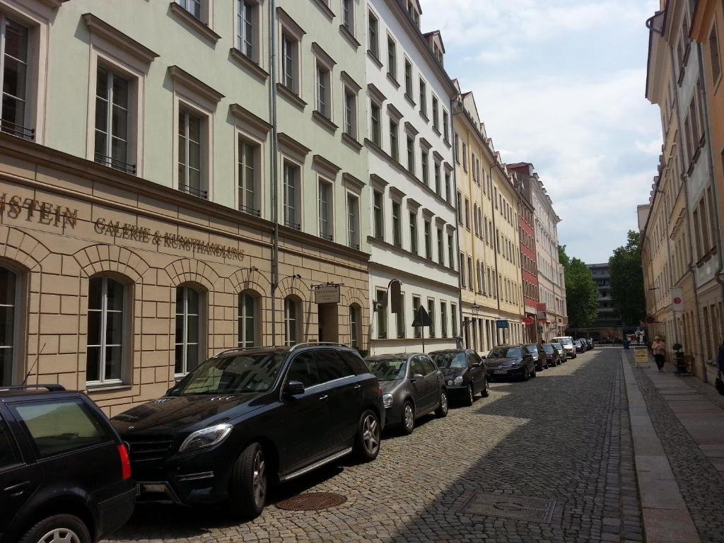 德累斯顿Ferienhaus im Barockviertel的停在建筑物旁边的街道上的一排汽车