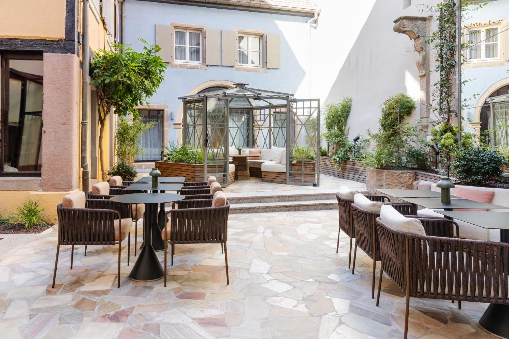 科尔马Hotel Le Colombier的餐厅的露台,配有桌椅
