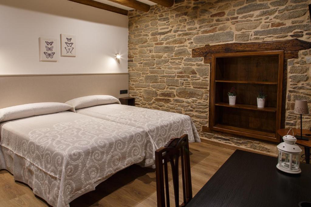 萨里亚卡萨巴兰宾馆的一间卧室设有一张床和砖墙